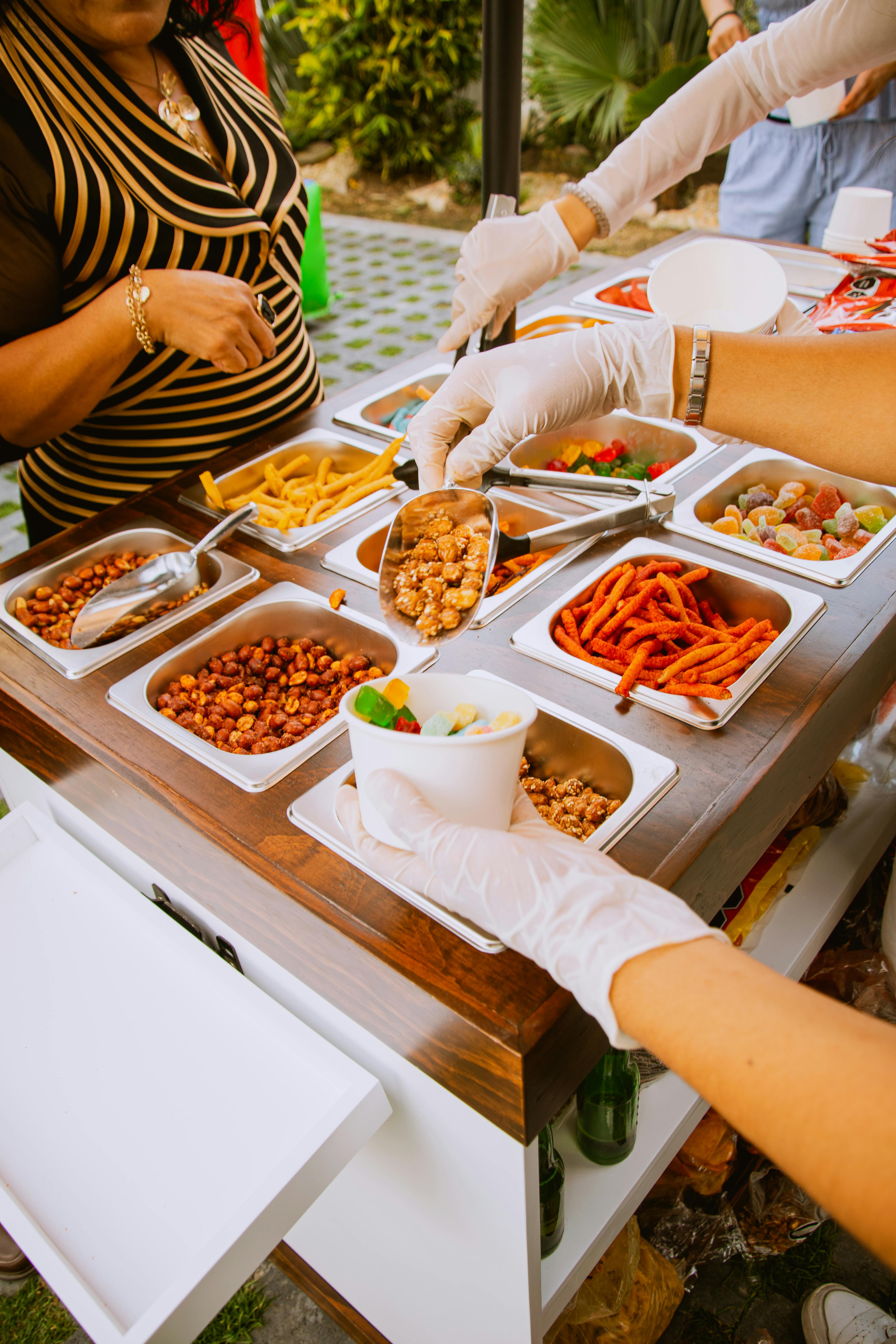 Outdoor food vendor serving snacks including fries and nuts at a food cart.