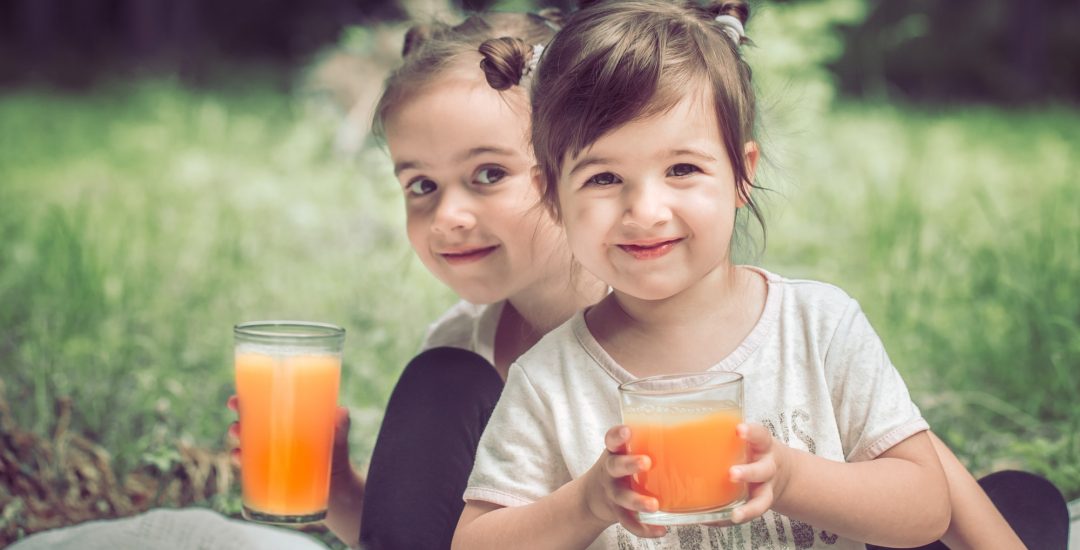two-little-sisters-drinking-juice.jpg